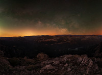 Milky Way core rising horizontally on horizon from mountain edge and above a grand valley