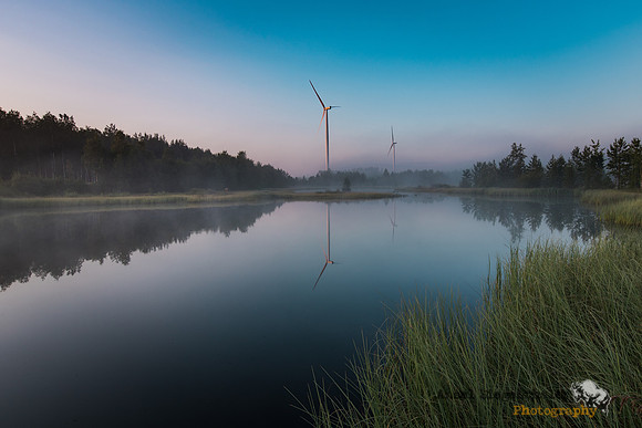 Morning light on pond and wind turbines