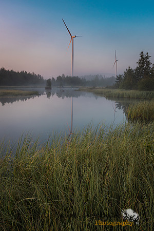 Morning light on pond and wind turbines