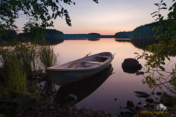 Rowboat docked on shore in evening twilight