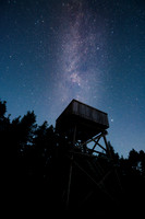 Starry night sky with lookout tower