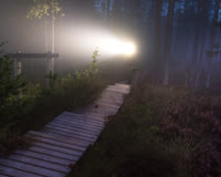 Person on path with headlamp in dawn fog
